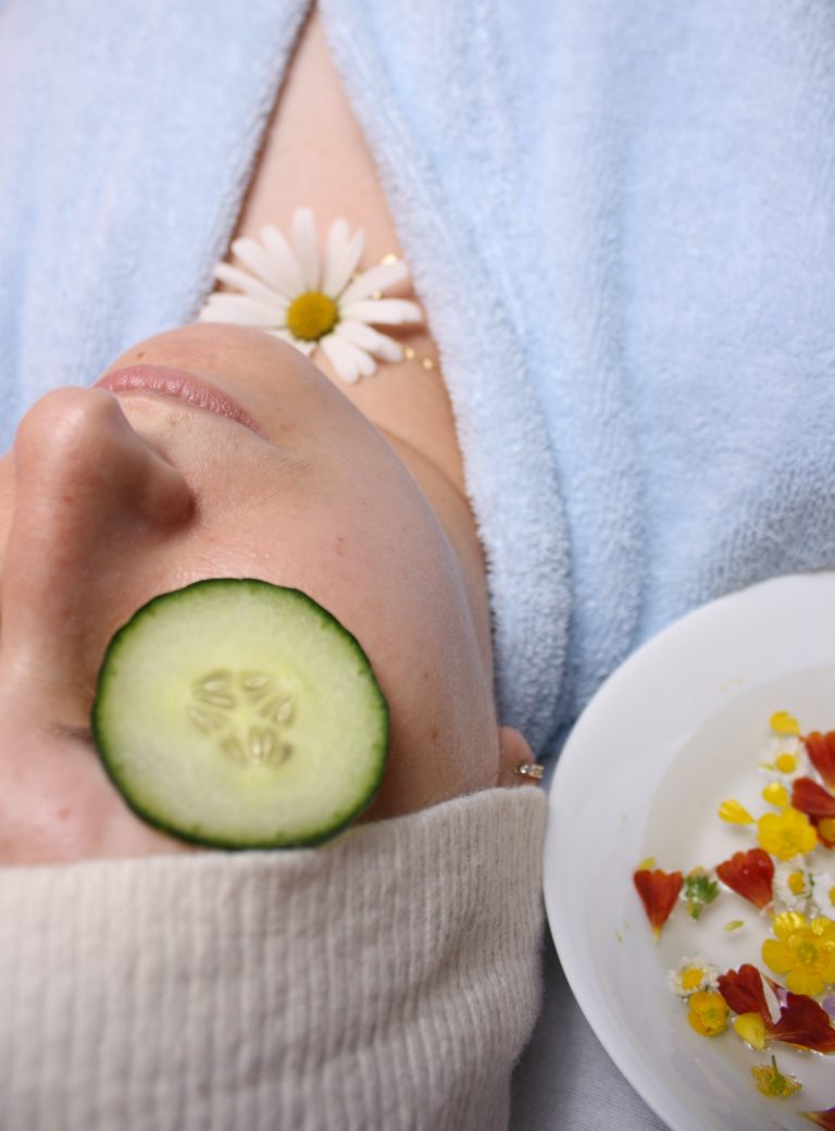 A client at Brazilian Wax and Spa by Claudia lays with a cucumber on her face